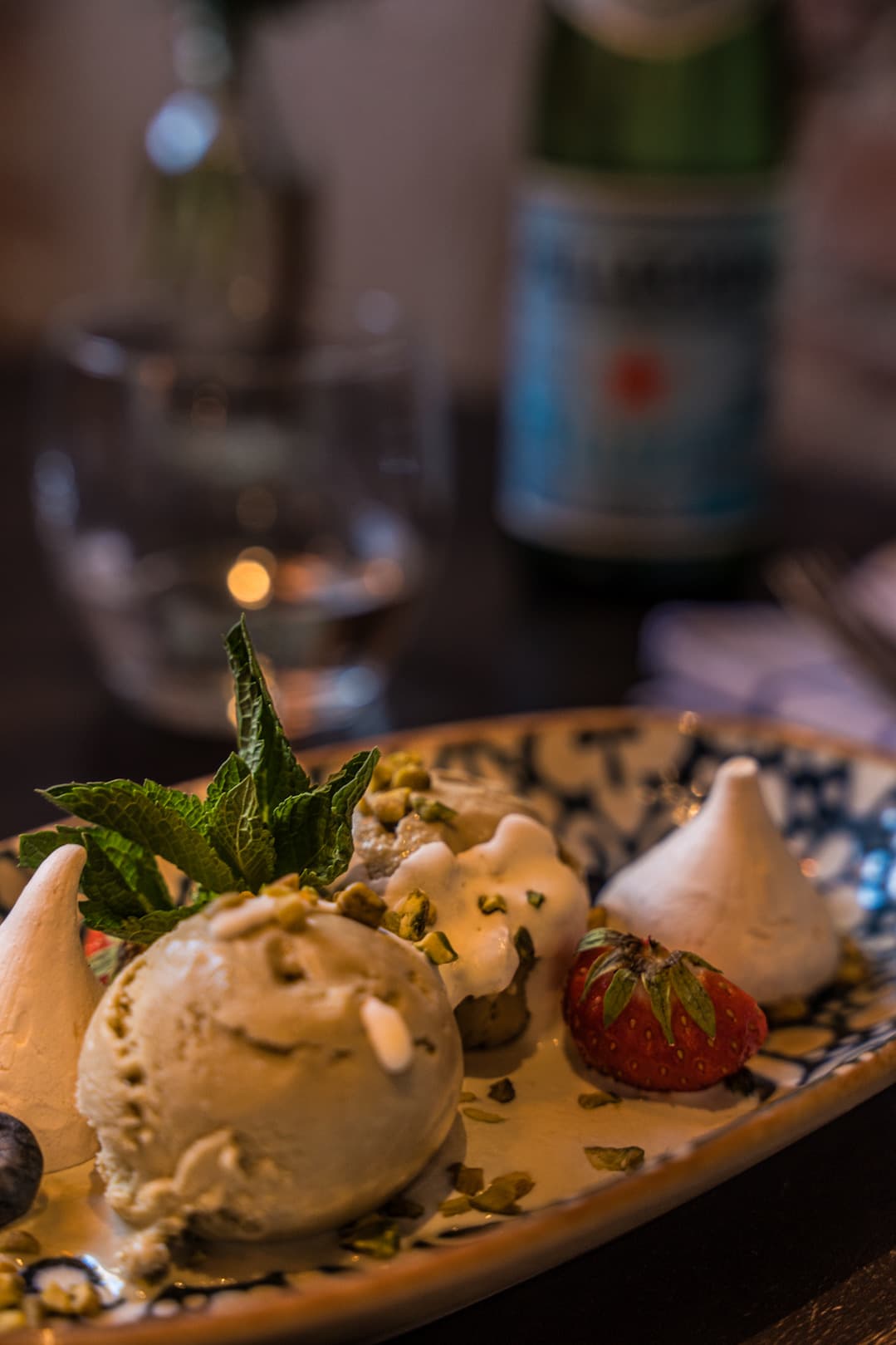 Ice cream, meringue and a strawberry, San Pellegrino behind