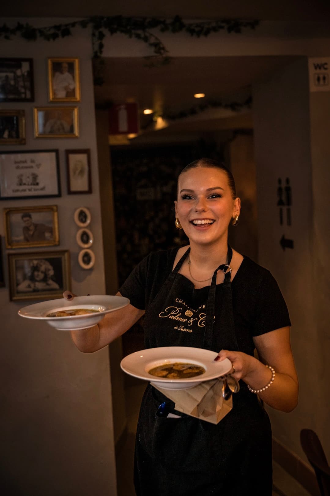 Server carrying two plates through the dining room