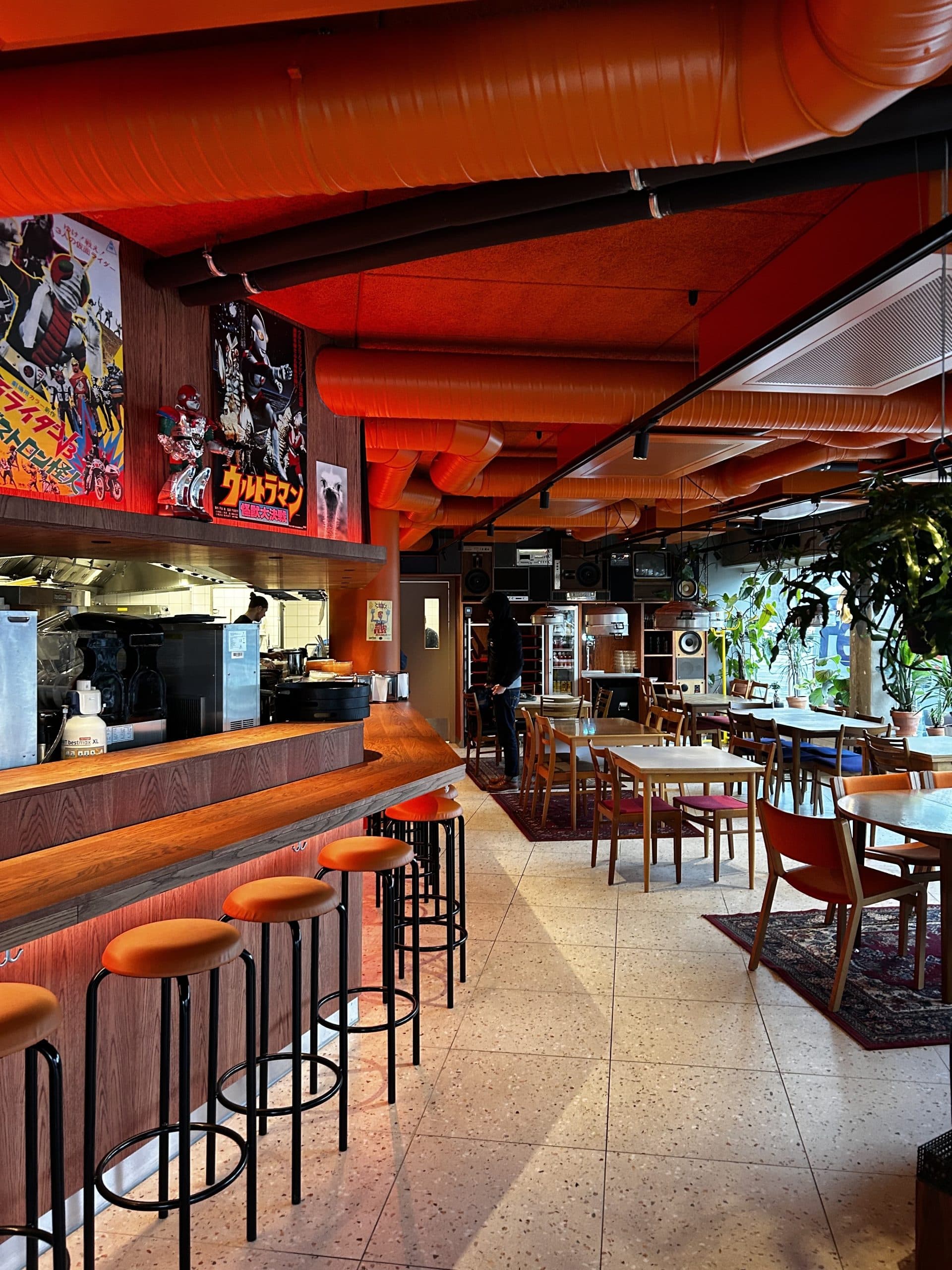 The dining room — orange ventilation, Japanese film posters, a counter with stools